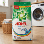 Bag of Ariel laundry detergent (10 kg) with Lenor, on a wooden laundry-room floor in front of a washing machine